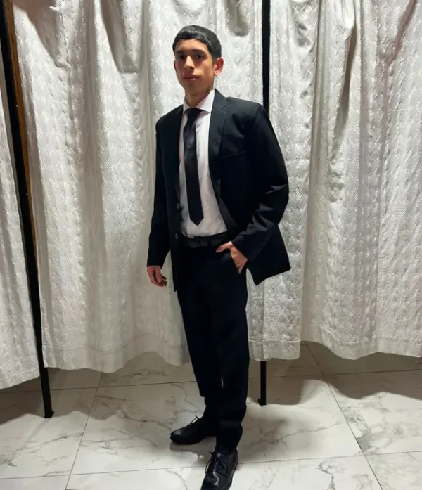 Hombre vistiendo pantalón de vestir negro ajustado slim fit con camisa blanca y cinto negro de sastrería juan