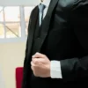 Hombre vistiendo pantalón de vestir negro ajustado slim fit con camisa blanca y cinto negro de sastrería juan